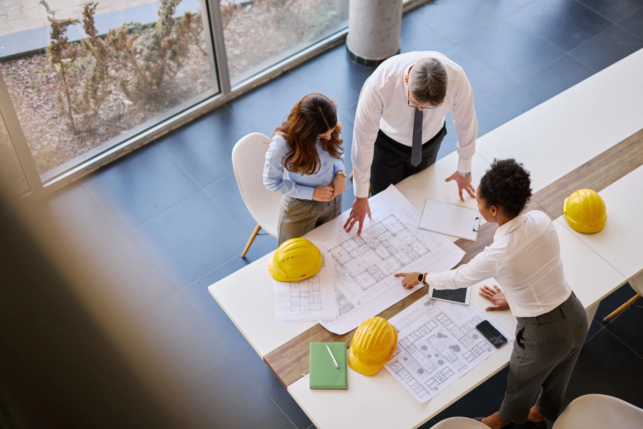Project team collaborating over construction plans in an office
