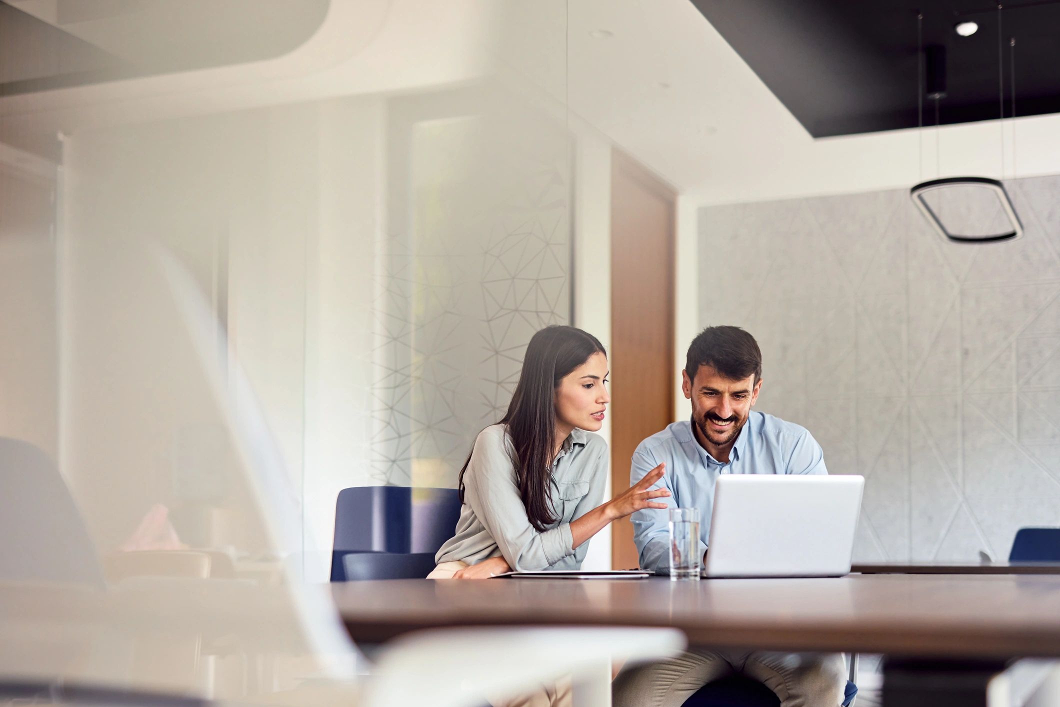 Consultant collaborating with a client on a laptop